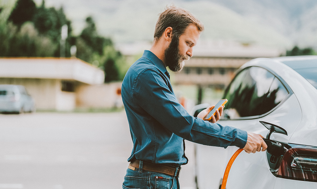 Photo of a hand connecting a car charging cable