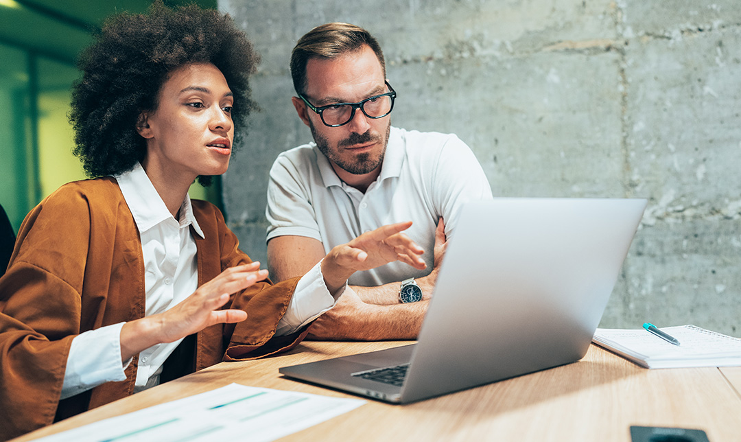 Photo of two office workers looking at a tablet