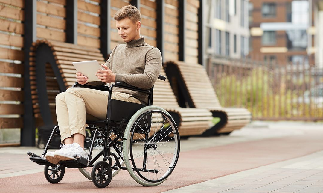 Photo of a man sitting in a wheelchair at a dining table