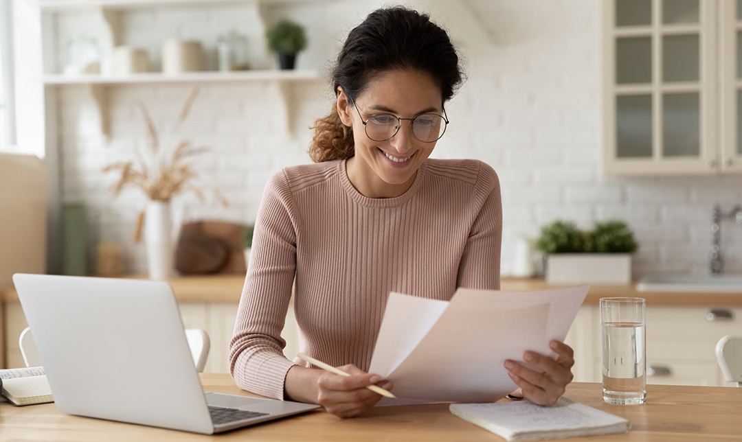 Photo of a female business owner using laptop whilst on phone