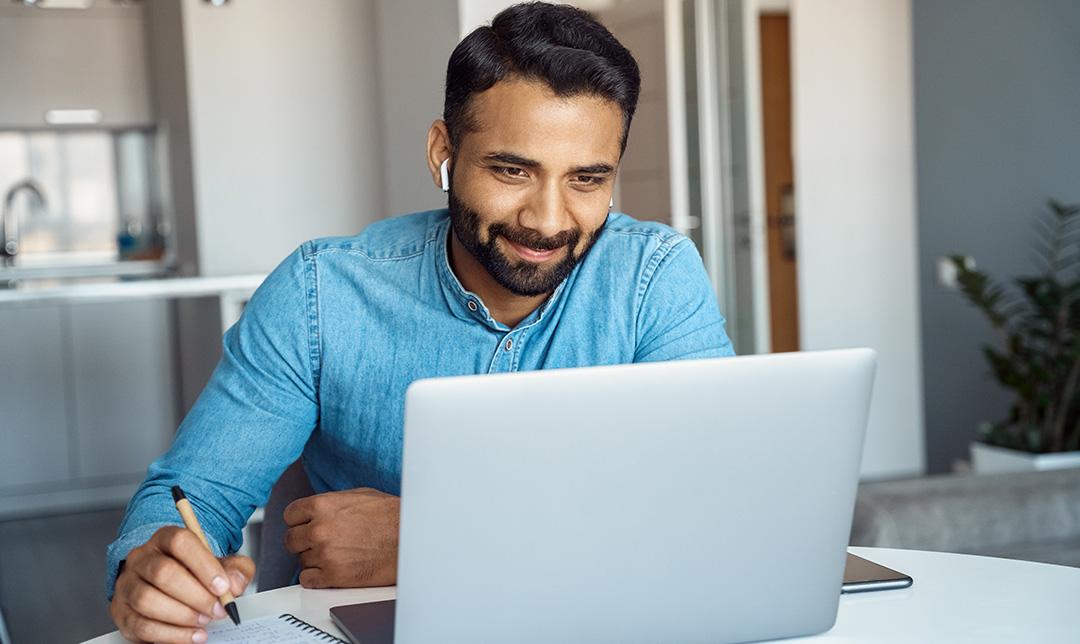 Photo of a man using laptop in living room at home