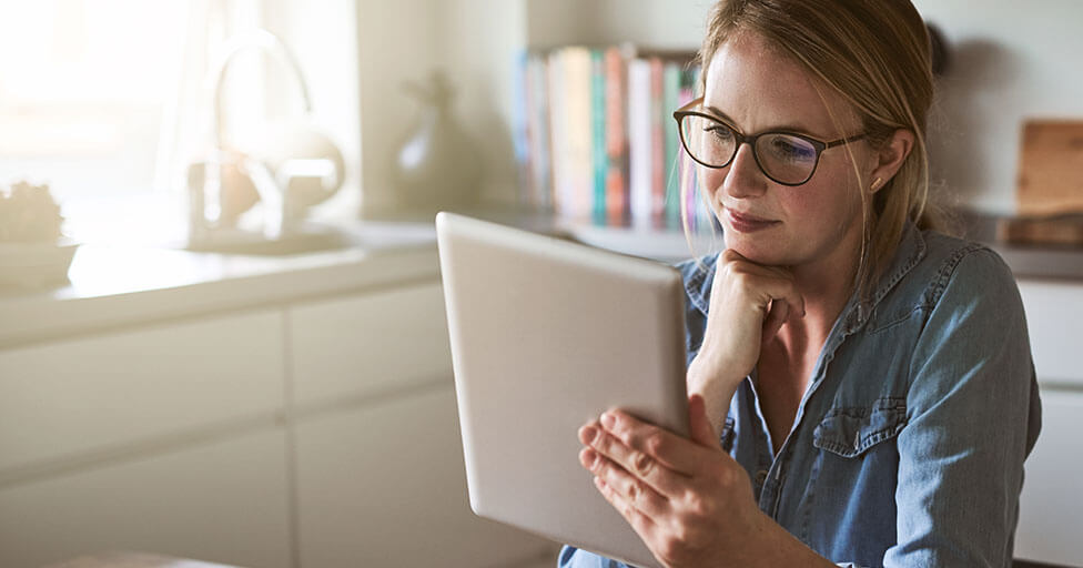 Image of a person holding an iPad in a kitchen