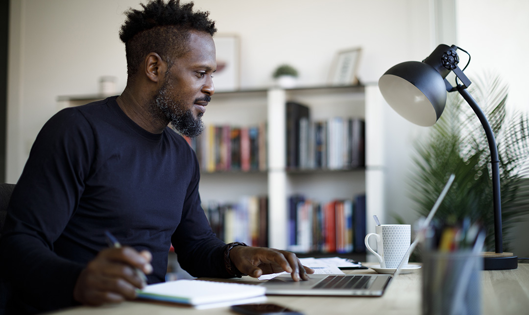 Young man sitting at his desk with pen and notepad 