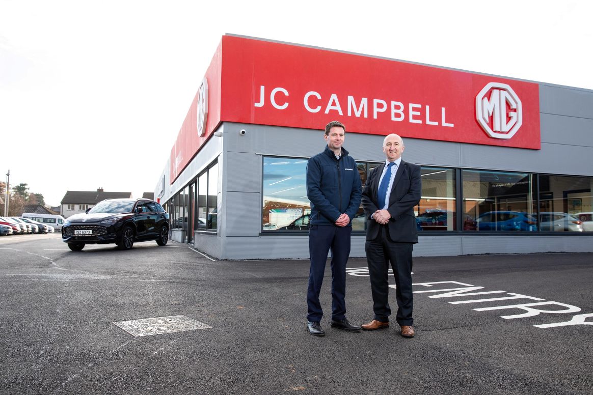 Two men standing outside JC Campbell MG building