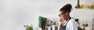 A kitchen manager discusses staffing needs on the phone.
