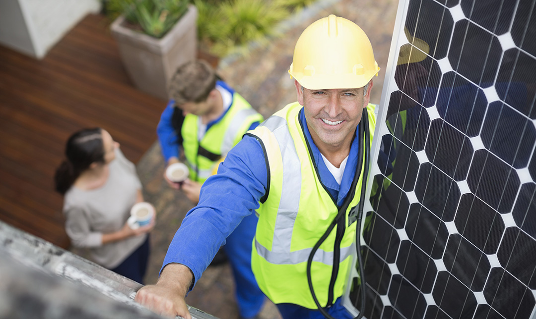 Photo of a number of solar panels on a white corrugated roof