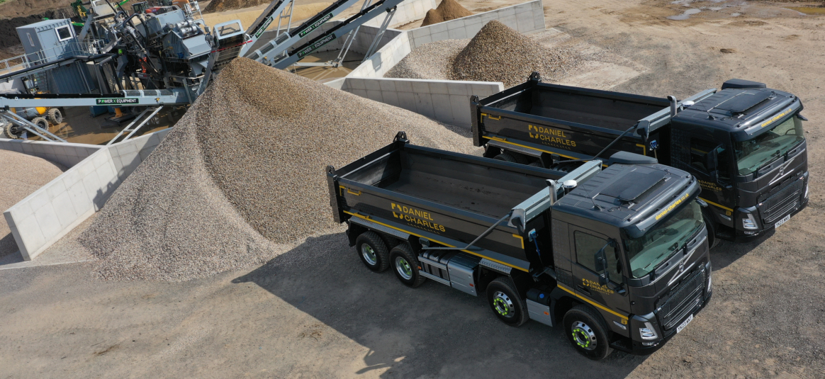 Two dumpster trucks on an aggregates construction site