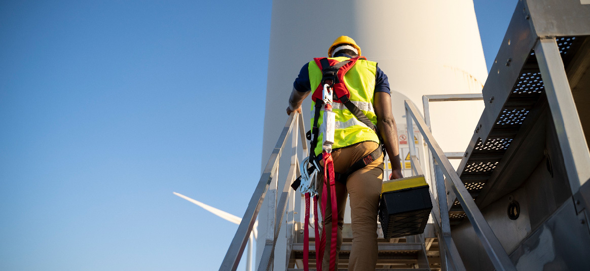 Photo of an engineer entering a wind turbine