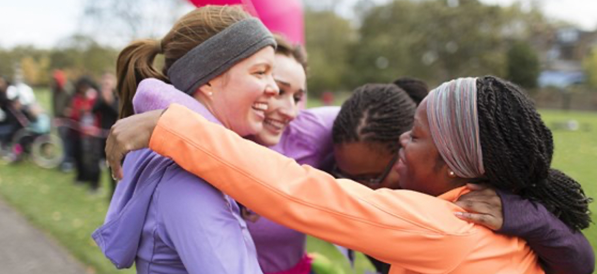 Runners congratulating each other in a group hug