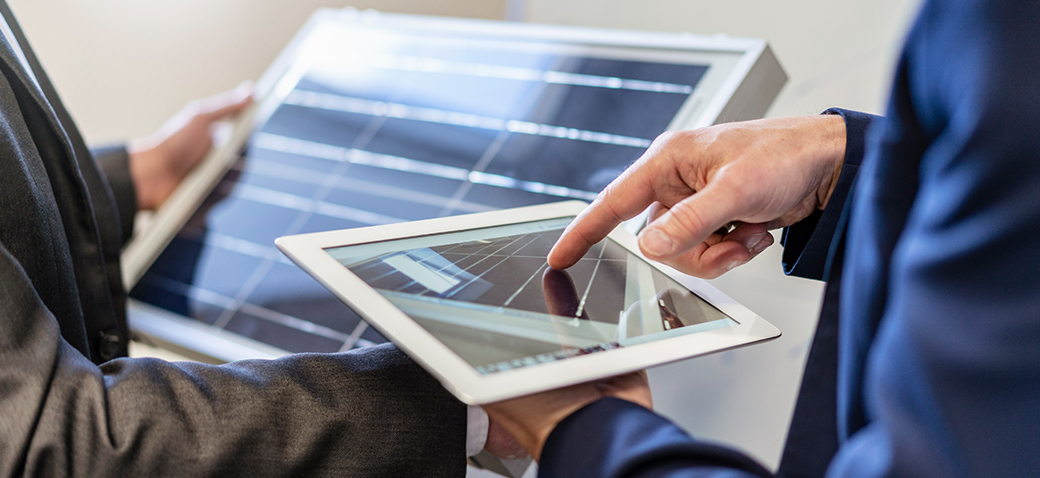 An office worker using a tablet to share information on another screen