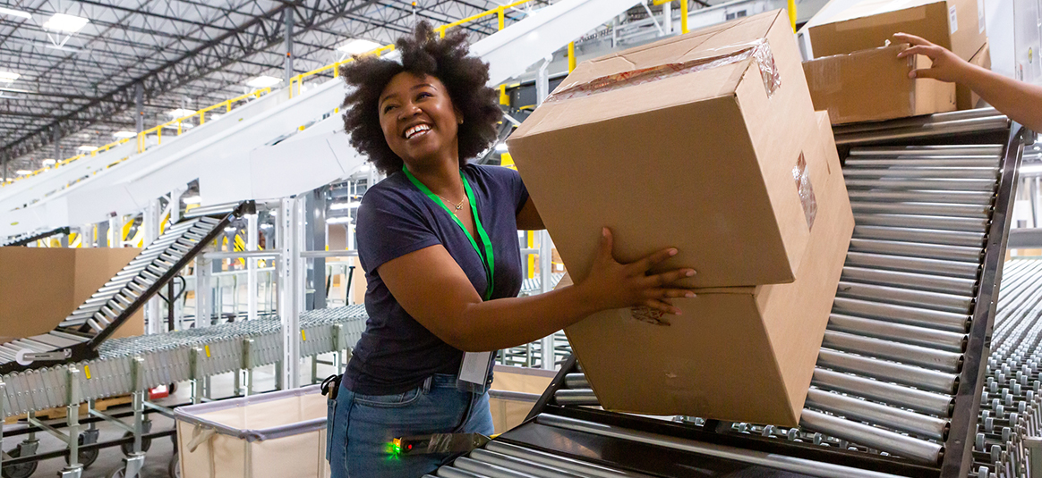 Photo of smiling female worker moving boxes