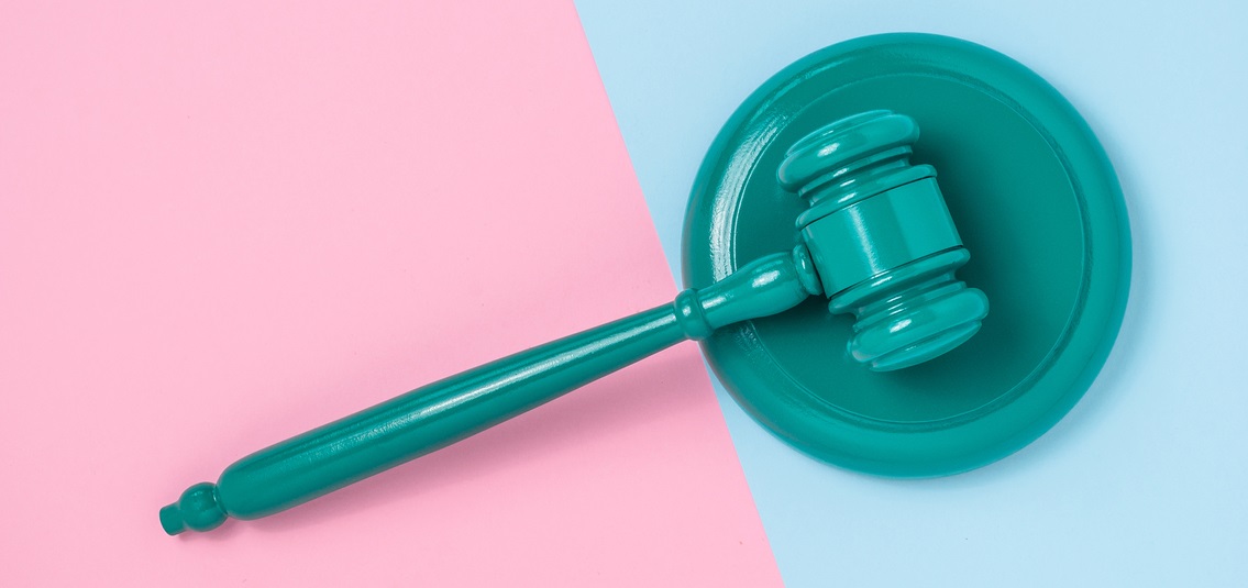 photo of a green gavel on a pink and blue table