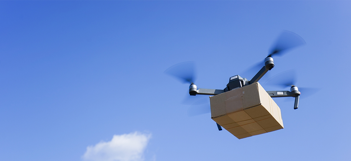 a drone carrying a cardboard box