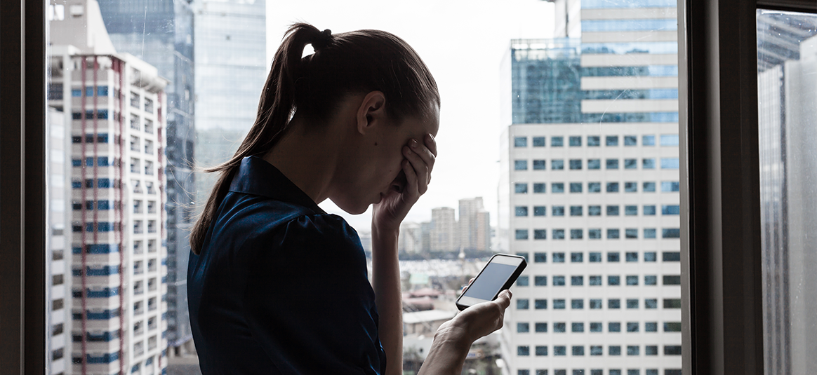 Photo of a person with a mobile device looking worried