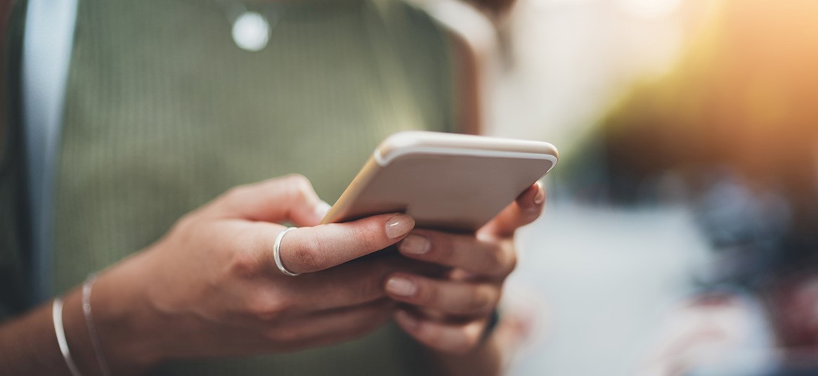 Photo of two hands holding a mobile phone.