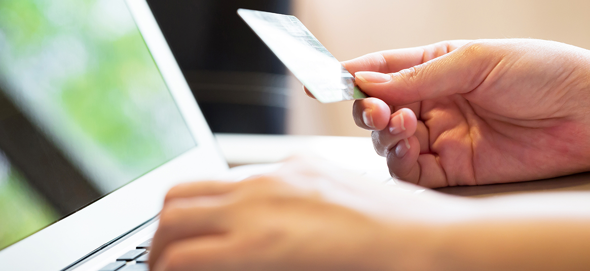 Online shopper entering card details on a laptop