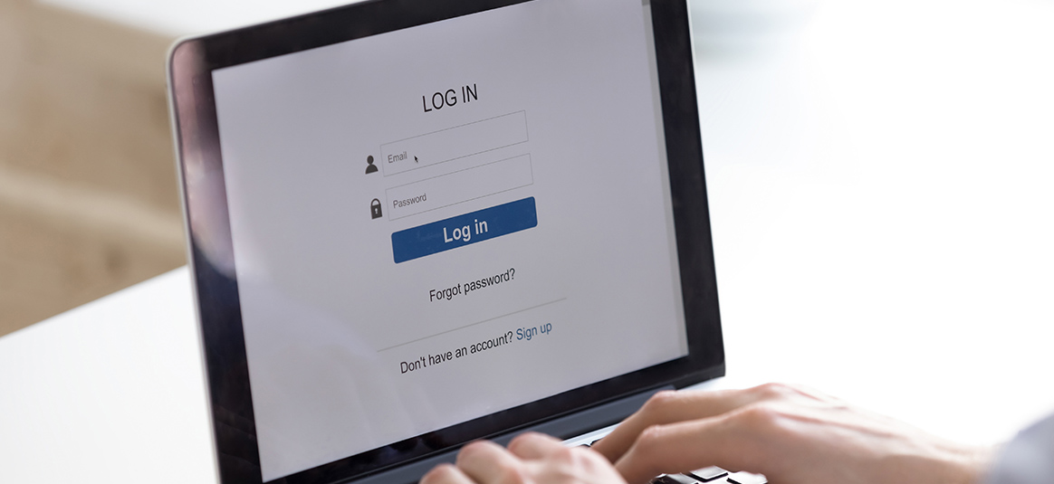 A person using a laptop at a log in screen prompted to enter email and password