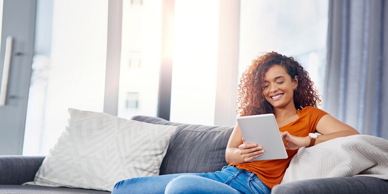 Woman sitting on couch with an iPad